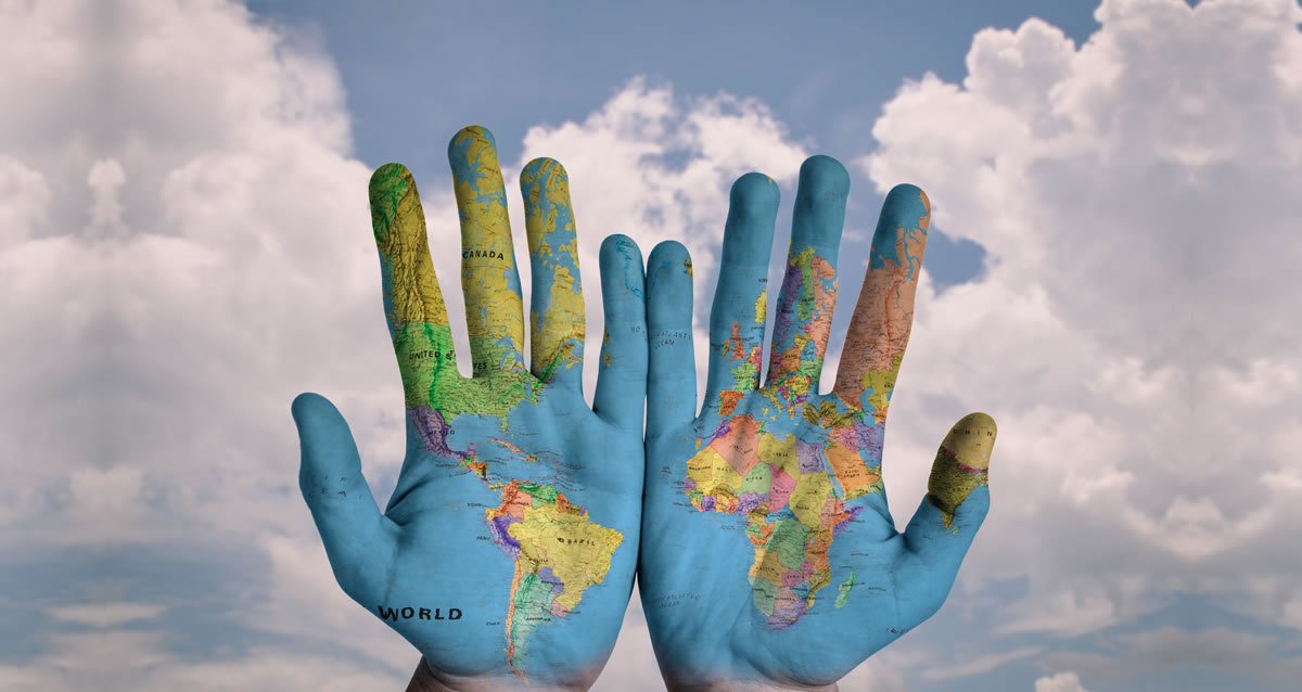 ccls language school. Image description: hands with the world´s map painted in it with a cloudy sky background.